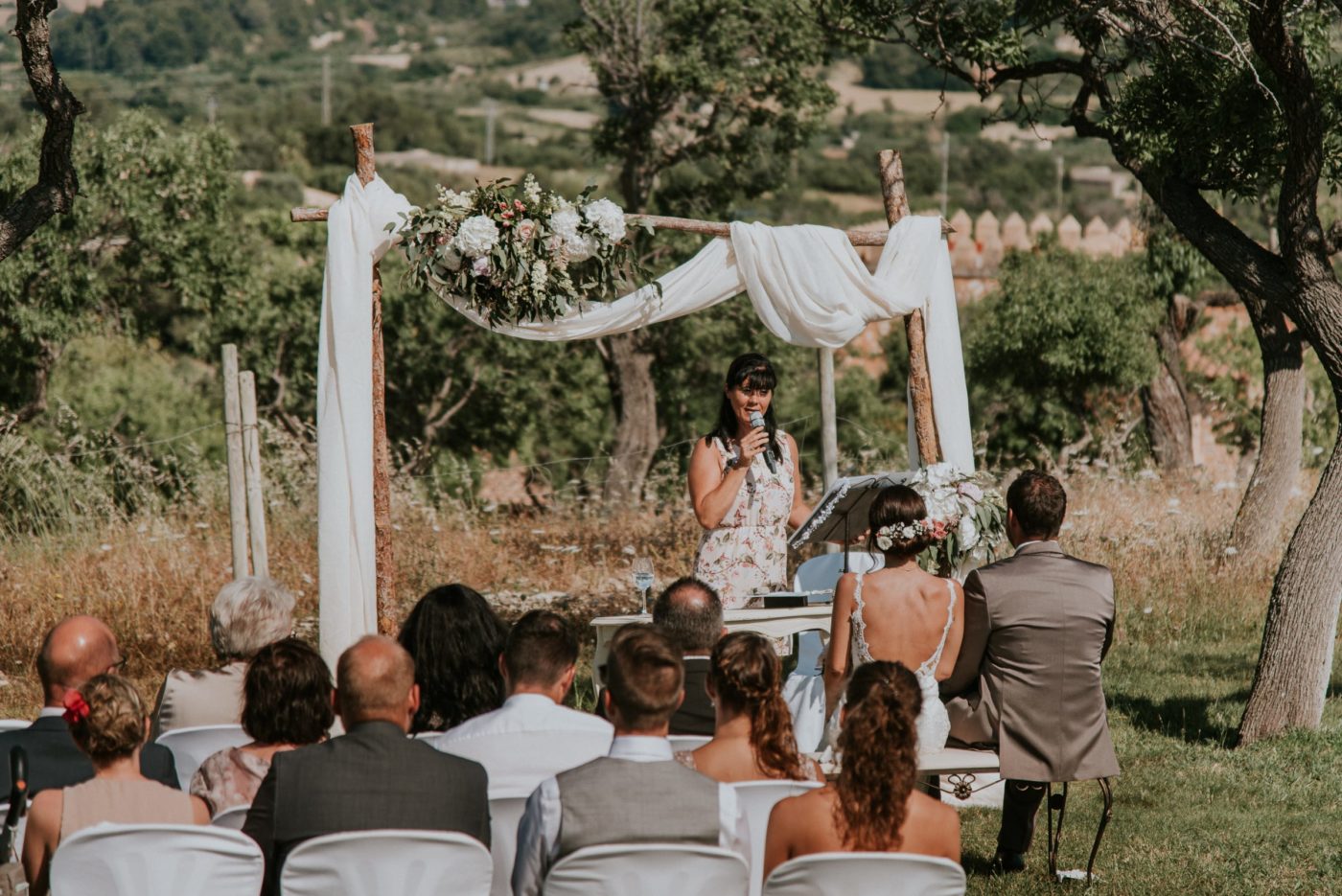 Die Hochzeitszeremonie von einem erhöhten Punkt fotografiert. Man sieht im Hintergrund das wunderschöne Grün der mallorquinischen Landschaft.